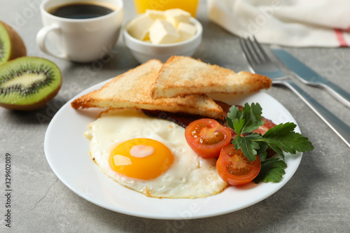 Delicious breakfast or lunch with fried eggs on grey background, close up