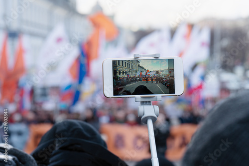 Blogger is reporting using a smartphone from a city street during a mass political action in Moscow, Russia. photo