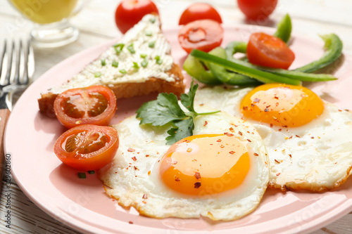 Delicious breakfast or lunch with fried eggs on wooden background  close up