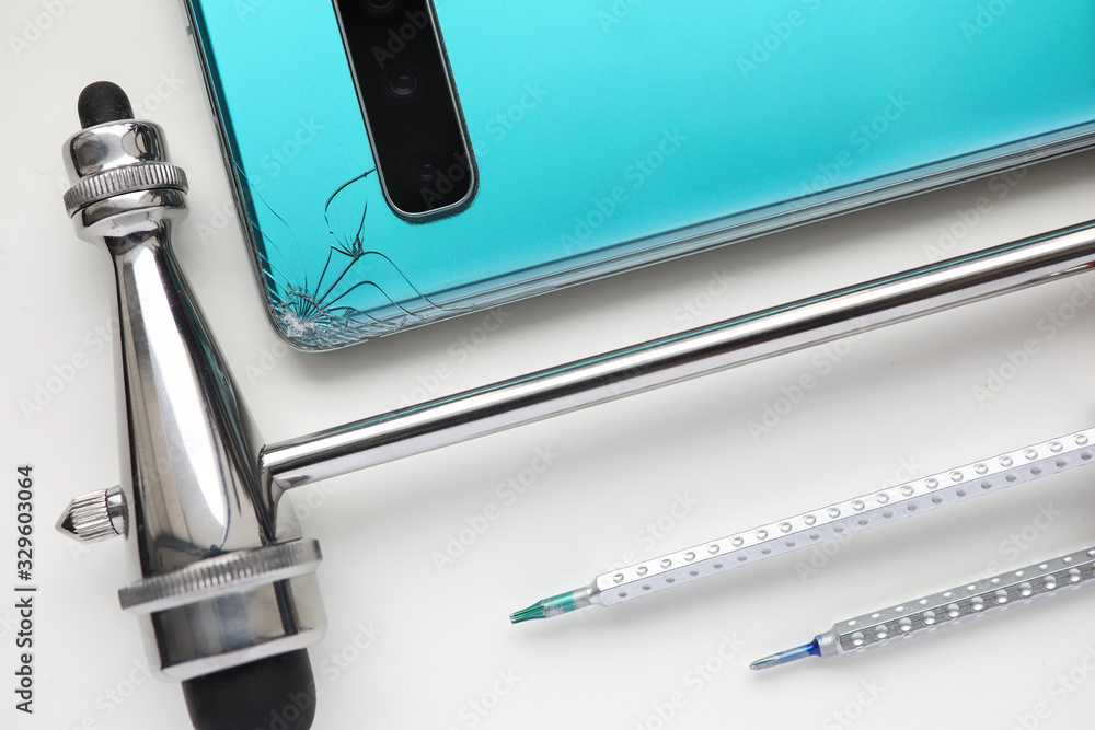Modern smartphone lying at table with crack in corner Modern smartphone lying at table with crack in corner