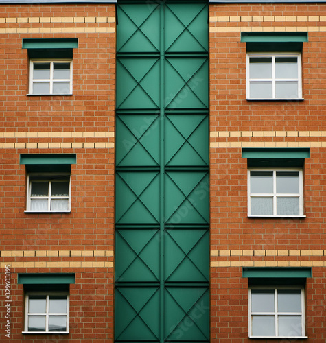 Facade symmetry in Berlin building Germany With windows and brick Green and red