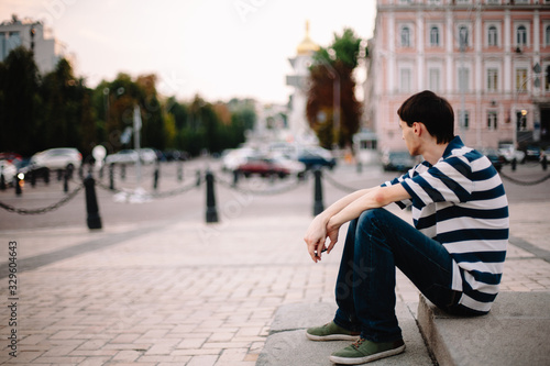 Cuadro en lienzo Sad hopeless desperate depressed young man sitting on stairs in city