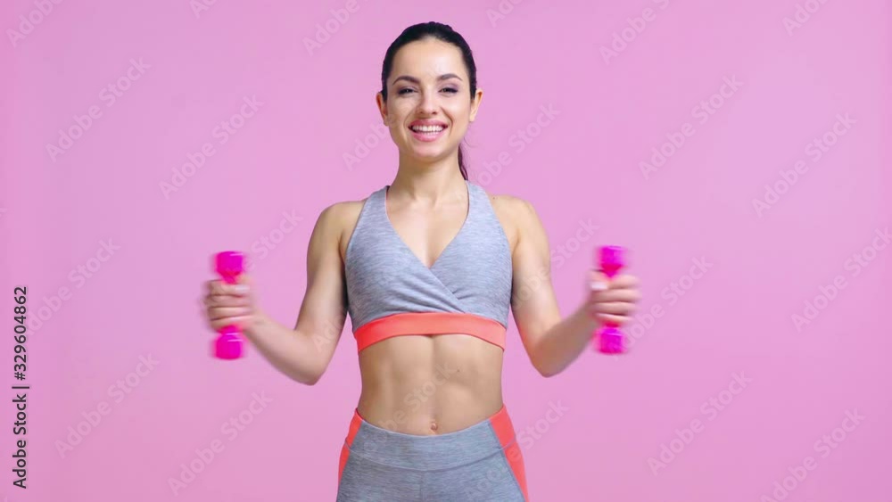 happy woman working out with dumbbells isolated on pink happy woman working out with dumbbells isolated on pink