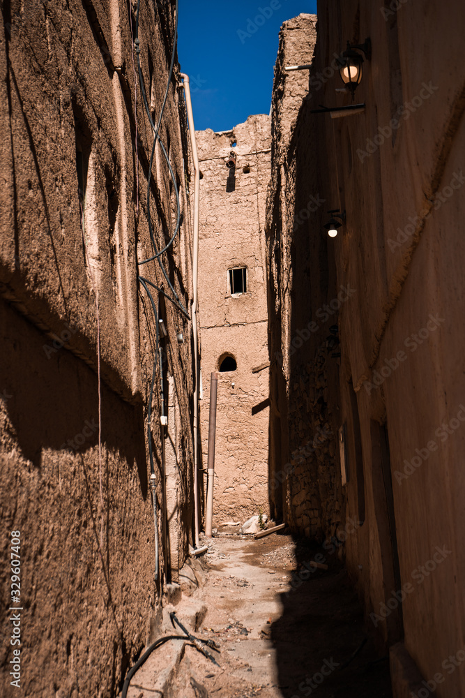 Narrow street between typical Oman adobe buildings