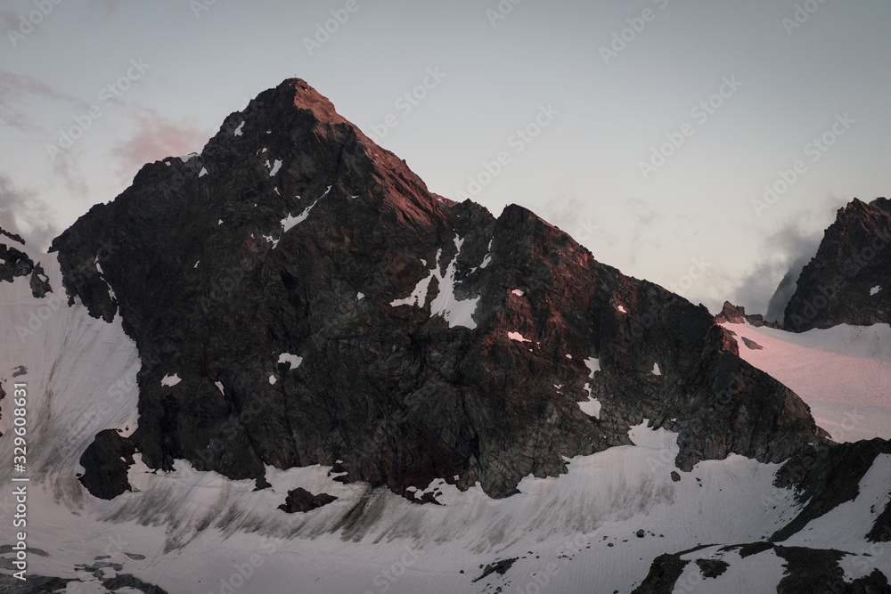 A massive snow covered mountain in Vorarlberg, Austria in the time of sunset