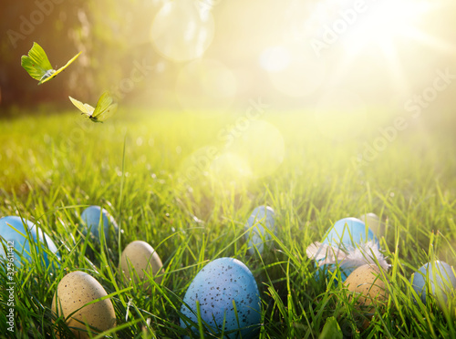 Art easter eggs on green grass at sunny day; easter banner background with copy space;