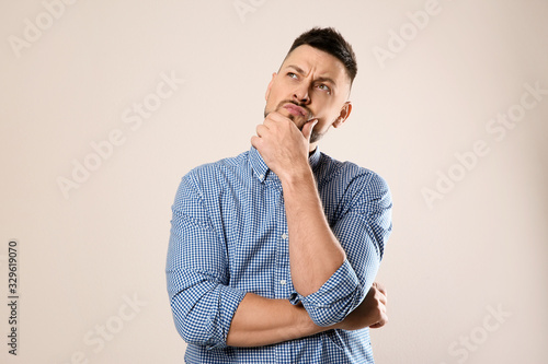 Emotional man in casual outfit on grey background photo