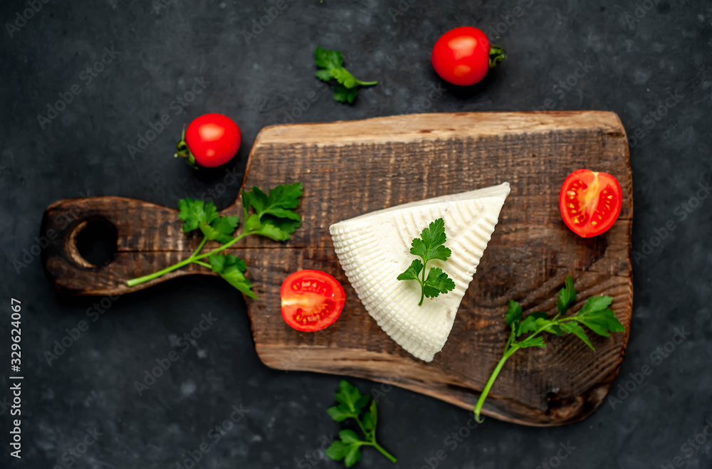 feta cheese on a cutting board on a stone background feta cheese on a cutting board on a stone background