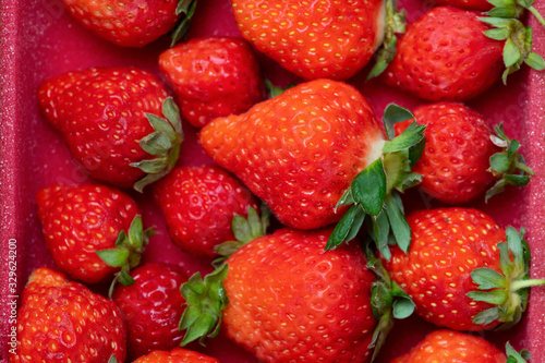 Fresh strawberries in white porcelain plate on wooden table