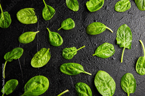 Spinach green fresh leaves with water drops on a black background © mikeosphoto