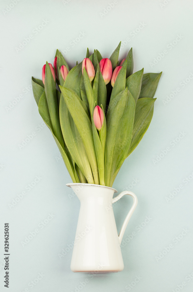 Fresh white tulip flowers bouquet in front of white brick wall.