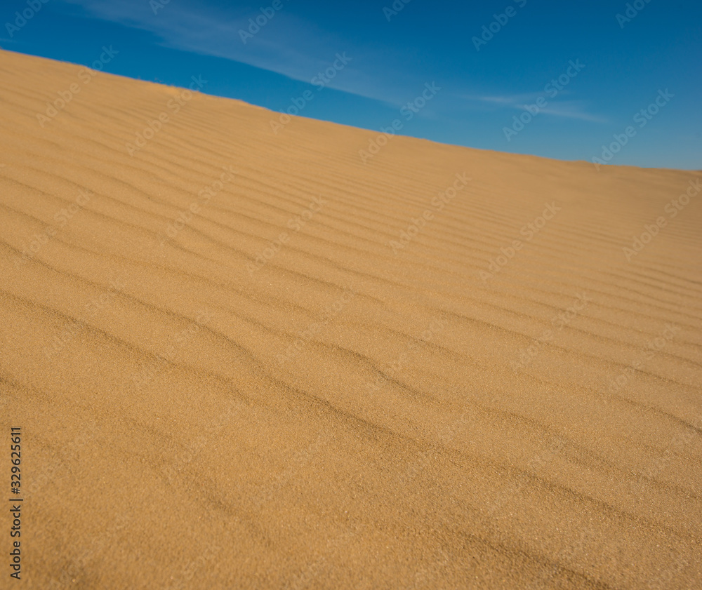 Blue sky and sand surface in the dunes.