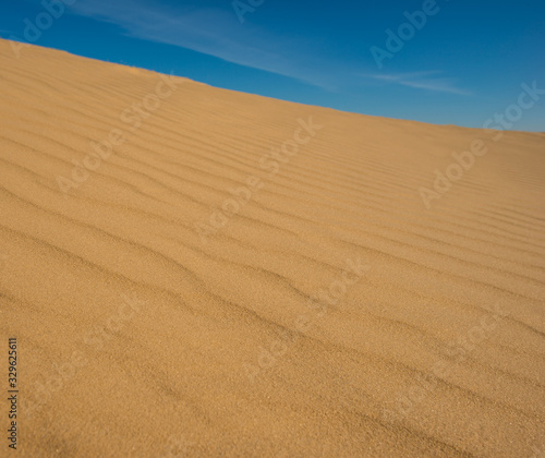 Blue sky and sand surface in the dunes.