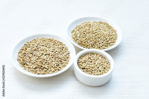Seed of birdseed, food for birds, displayed in containers on white wooden background