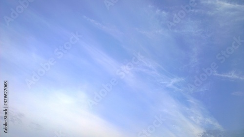 Blue sky with blurry white clouds. Shades of color. Tenderness, dreams and inspiration. Copy space. Beautiful abstract background. Fresh air concept. Environment. 