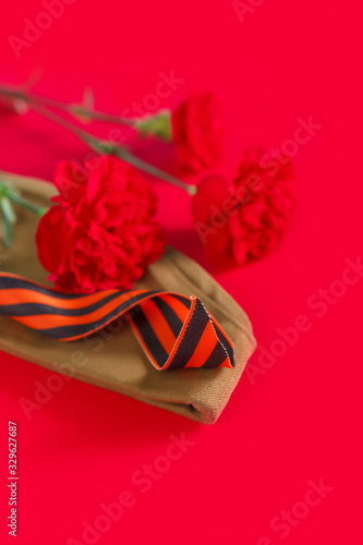 Fototapeta Naklejka Na Ścianę i Meble -  May 9, Victory Day holiday. Holiday card with order, St. George ribbon, flowers and military cap. May 9 background, copy space and translation with Victory Day.