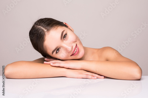 Beauty portrait of a young attractive half naked woman with perfect skin posing and looking away over white background
