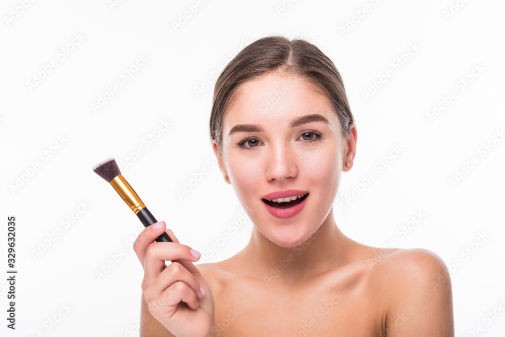 Closeup portrait of a woman applying dry cosmetic tonal foundation on the face using makeup brush isolated on white background Closeup portrait of a woman applying dry cosmetic tonal foundation on the face using makeup brush isolated on white background