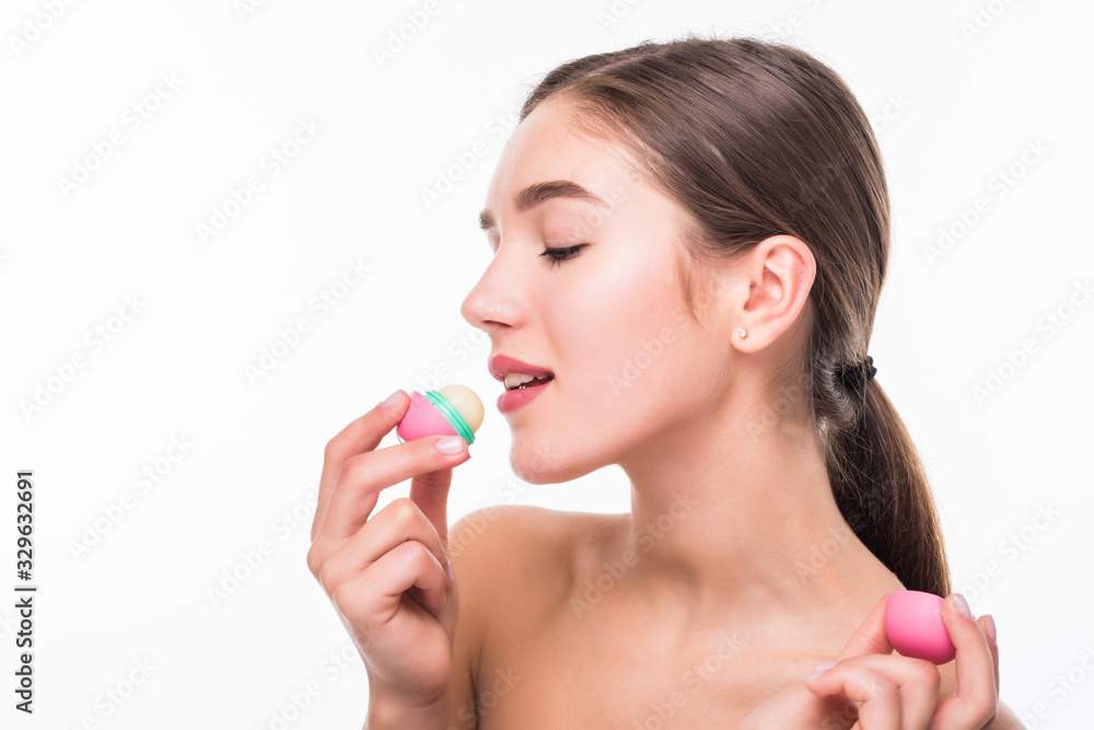 Young woman applying hygienic lip balm on white background Young woman applying hygienic lip balm on white background