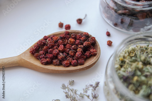  dried hawthorn on a wooden spoon close-up on a light background photo