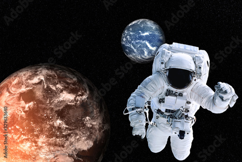 Astronaut near Planets of solar system together in space. Earth and Mars  Science fiction wallpaper. Elements of this image were furnished by NASA.