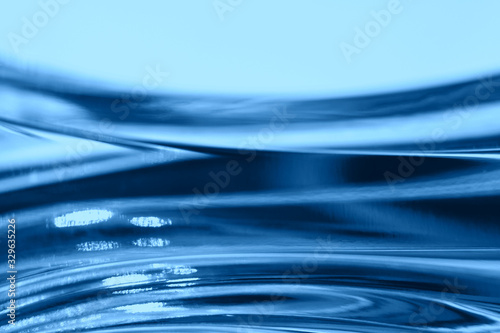 Abstract blurred soft focused futuristic dark blue glass wavy background. 2020 trend color concept photo