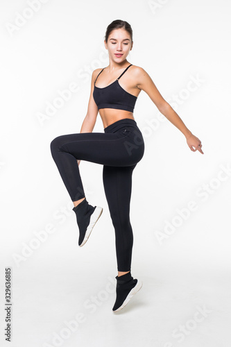 Full length picture of jumping fitness woman over gray background