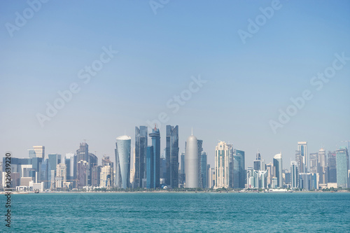 Panoramic view of modern skyline of Doha through the blue water. Concept of wealth and luxury © Hladchenko Viktor