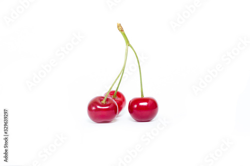 three cherries on a white background, ripe fruit