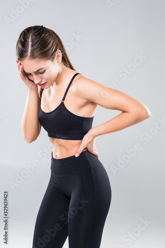 Attractive sportswoman with headache touching temples isolated on white background © dianagrytsku