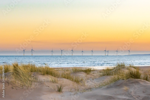 Offshore windfarm with sand dunes in the foreground 