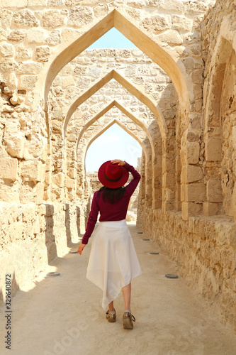 Female Visitor Walking along the Iconic Archways of Ancient Bahrain Fort in Manama, Bahrain © jobi_pro