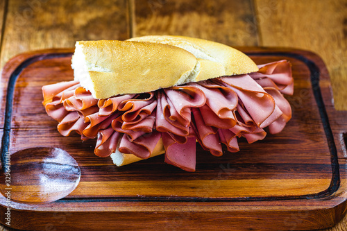 sliced ​​pork sandwich. Fatty, cooked meat snack. In Brazil it is called bread with mortadella. photo