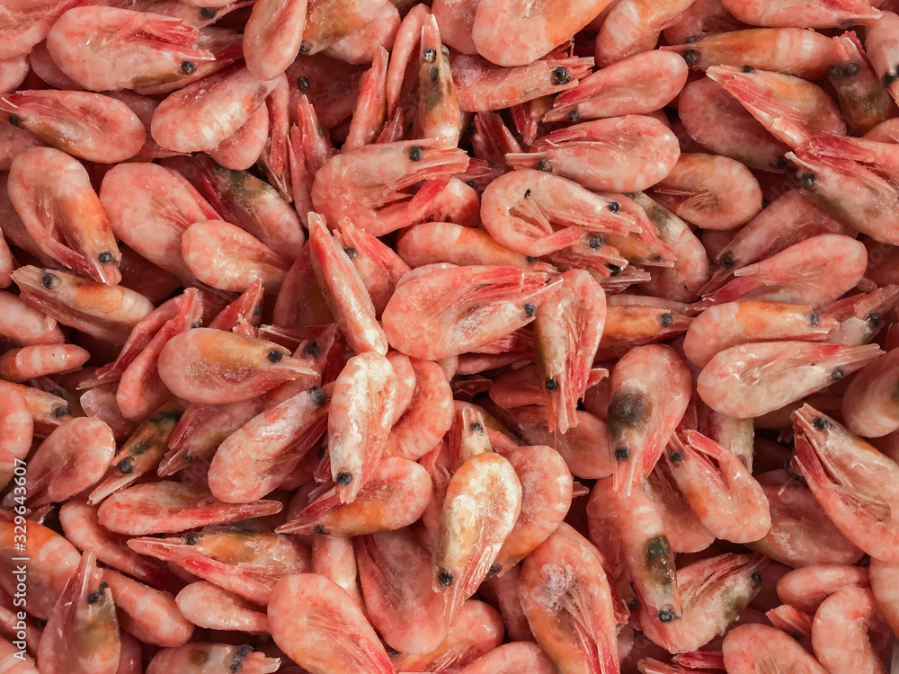 Close-up of a pile of frozen pink shrimps. Natural pink seafood background Close-up of a pile of frozen pink shrimps. Natural pink seafood background