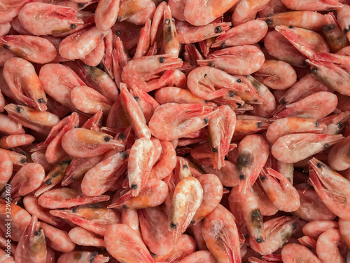 Close-up of a pile of frozen pink shrimps. Natural pink seafood background
