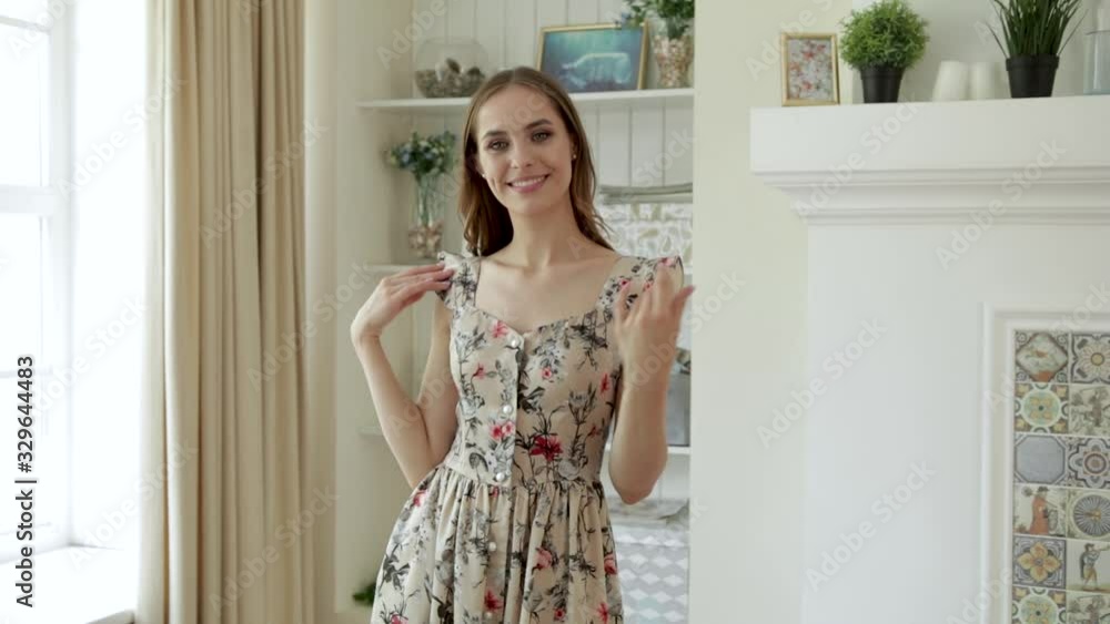 A young girl dancing in a dress and jacket next to a chair and a window in a beautiful interior, in a house A young girl dancing in a dress and jacket next to a chair and a window in a beautiful interior, in a house