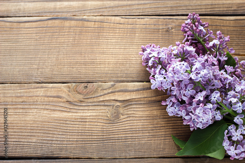 branch of purple lilac on a wooden background. Spring flowers on a wooden background with a place under the inscription