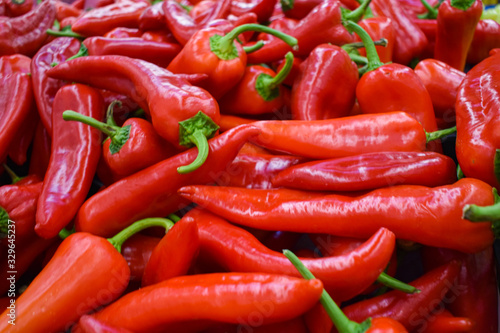 Heap Of Big Red Peppers At the market. red background. healthy eating.vegan style.