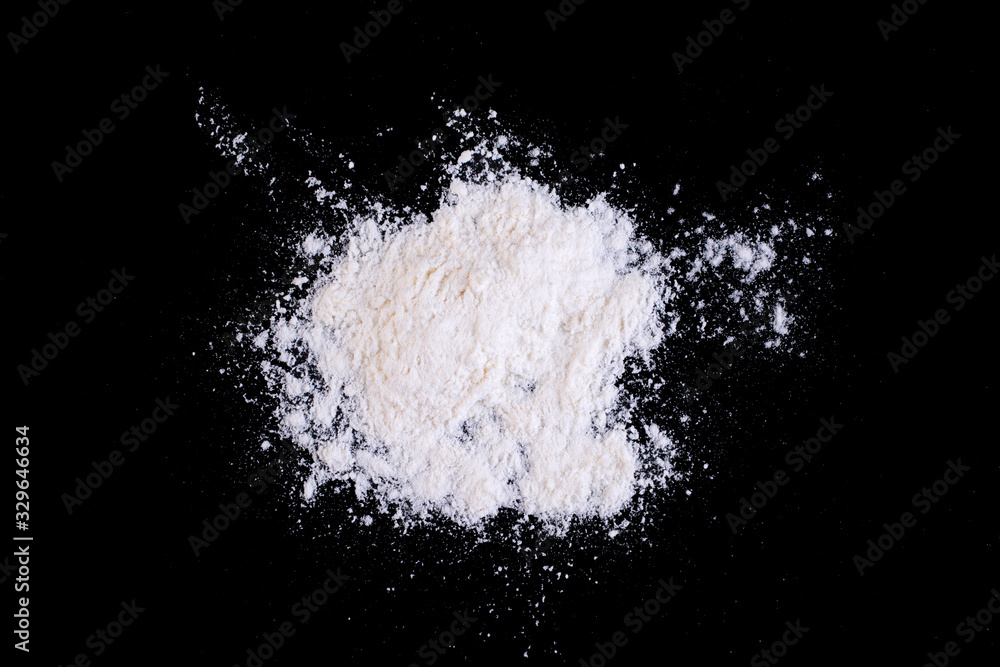 White wheat flour scattered on black glass. White wheat flour scattered on black glass.