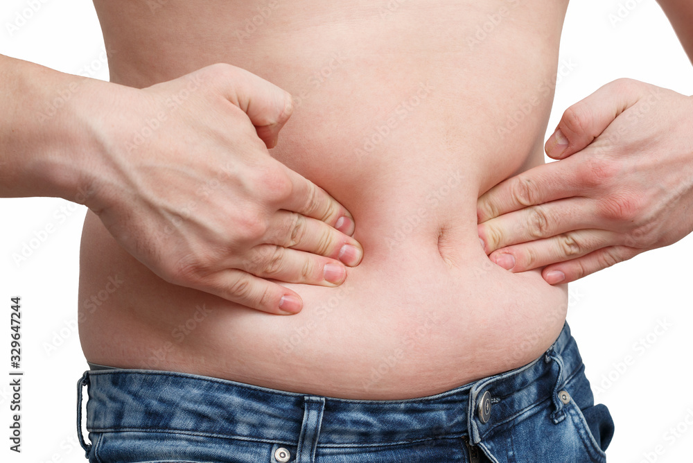 Fototapeta premium male hand presses the excess fat on your stomach