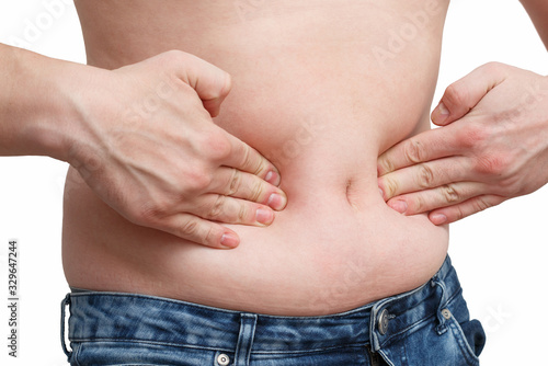 male hand presses the excess fat on your stomach