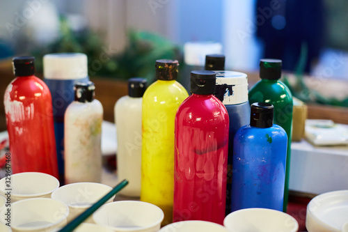 used bottles with acrylic paint are on the artist's desk