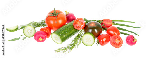 Fresh green cucumbers, different red tomatoes and bundle of green dill leaves isolated on white background. Ingredients for vegetable salad