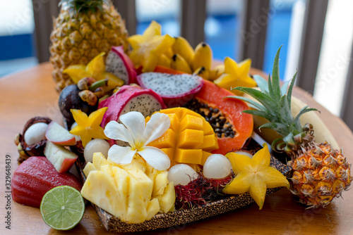 Juicy ripe tropical Thai fruits on a wooden dish.