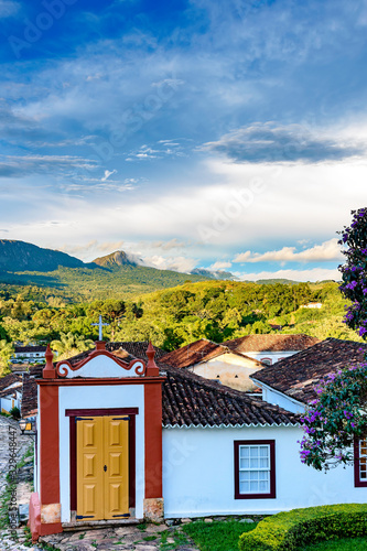 Fototapeta Naklejka Na Ścianę i Meble -  Stone streets of the old and historic city of Tiradentes, with its colonial architecture houses, a small 18th century church and the mountain and forest in the background