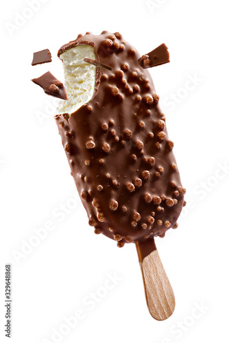 Fotografie Chocolate coated ice cream with crisps on a stick and pieces of chocolate on a w