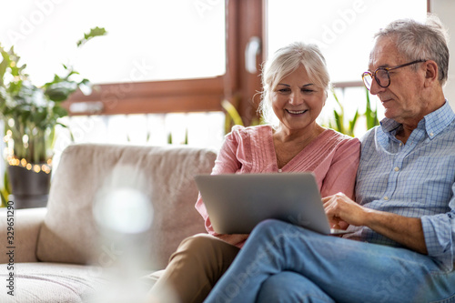 Mature couple using a laptop while relaxing at home photo