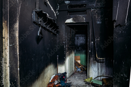 Consequences of fire. Burnt house interior. Charred walls and ceiling in black soot