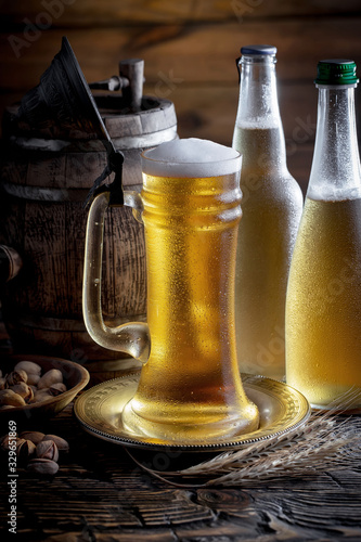 Light beer in a glass on a table in composition with accessories on an old background