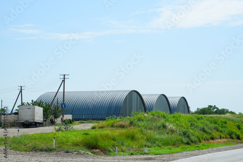 Large hangars made of galvanized corrugated a sheet iron.